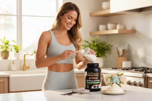Koko VitalWhey Velvet Reserve Birthday Cake - woman scooping protein with vanilla pods, sprinkles and buttercream on marble