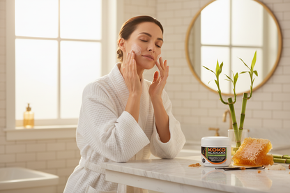 Koko Klarara lifestyle - woman massaging honey bamboo cleanser with raw honeycomb and botanicals on marble